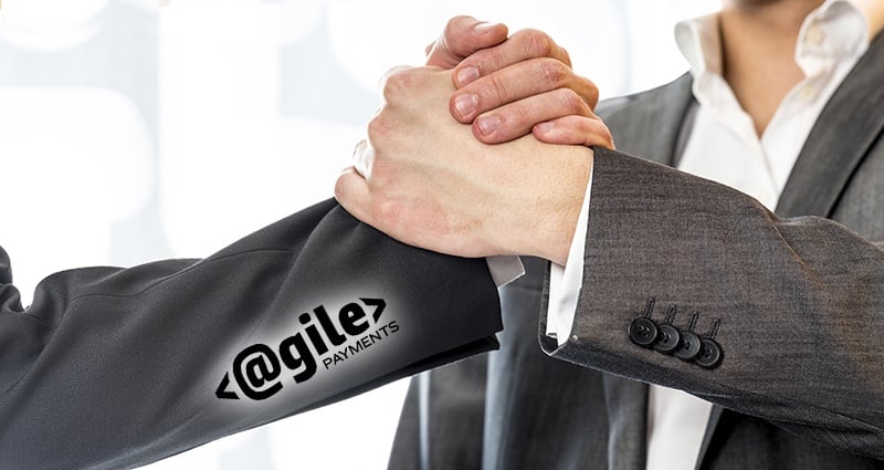 Close up of two businessmen in gray business suit gripping their hands in success and agreement at the office.
